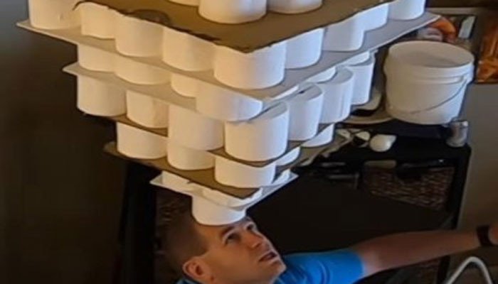 New record for balancing 254 toilet paper rolls on forehead